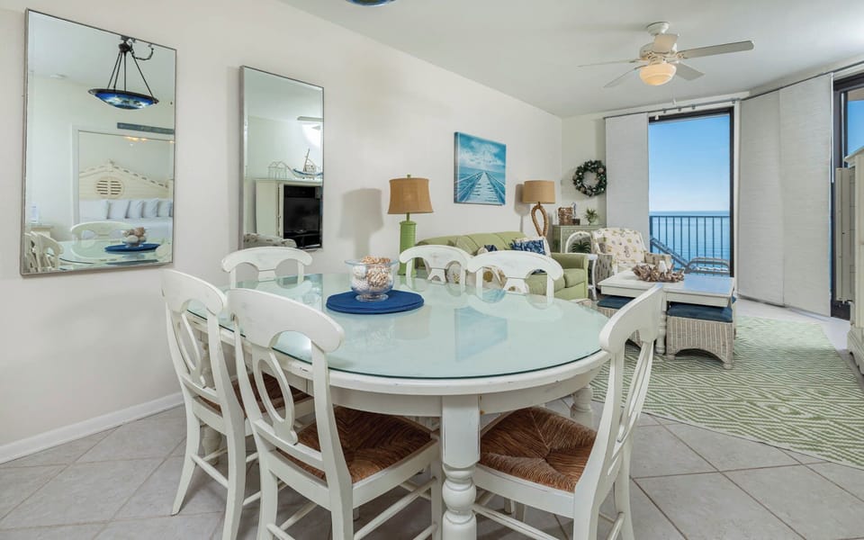 Gather around the oval dining table, enjoying the inviting decor and beach light streaming through the windows
