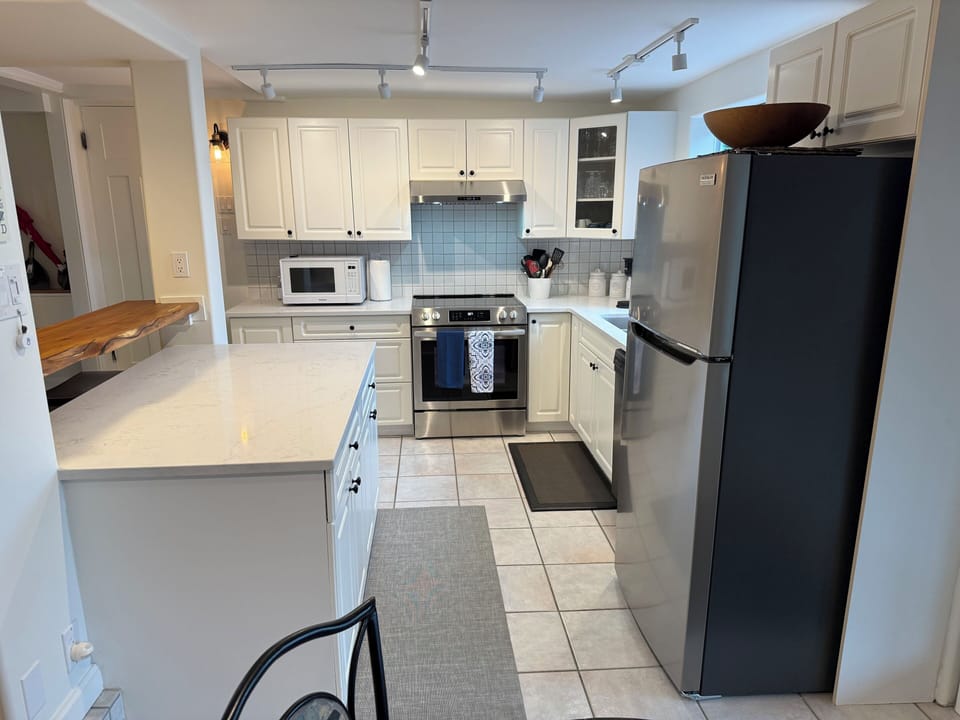 Newly renovated kitchen with stone countertops and new appliances.