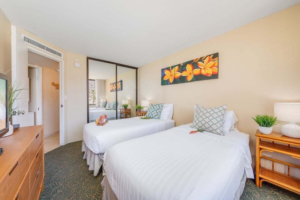 Inviting bedroom with plush convertible twin beds that transform into a king, crisp linens, and a full‑length mirror for a bright, comfortable retreat