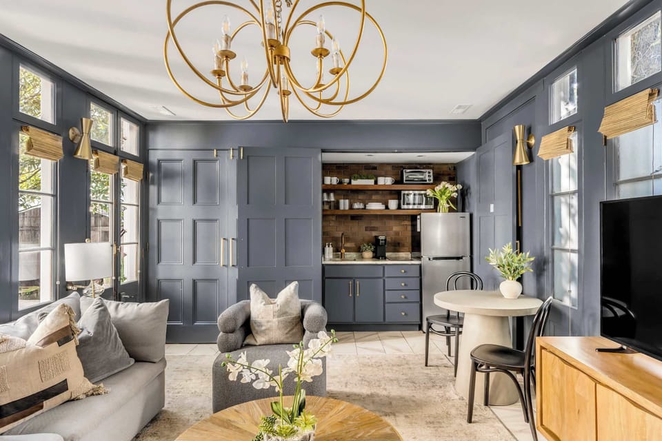 This view of the living room highlights the stylish kitchenette.