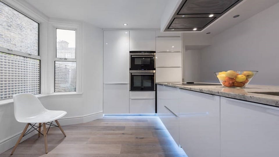 A chef's dream: sleek, modern kitchen with wood floors and high end  appliances.