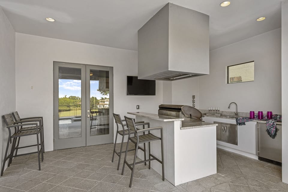 A summer kitchen is located underneath the covered lanai for delicious BBQ meals