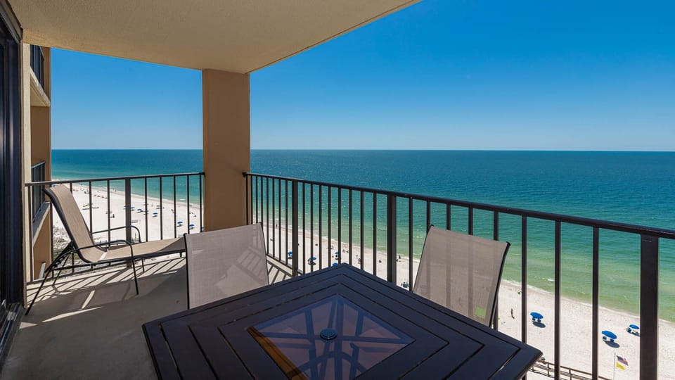Enjoy breathtaking views from this 12th floor balcony, featuring comfortable seating and a table perfect for relaxation