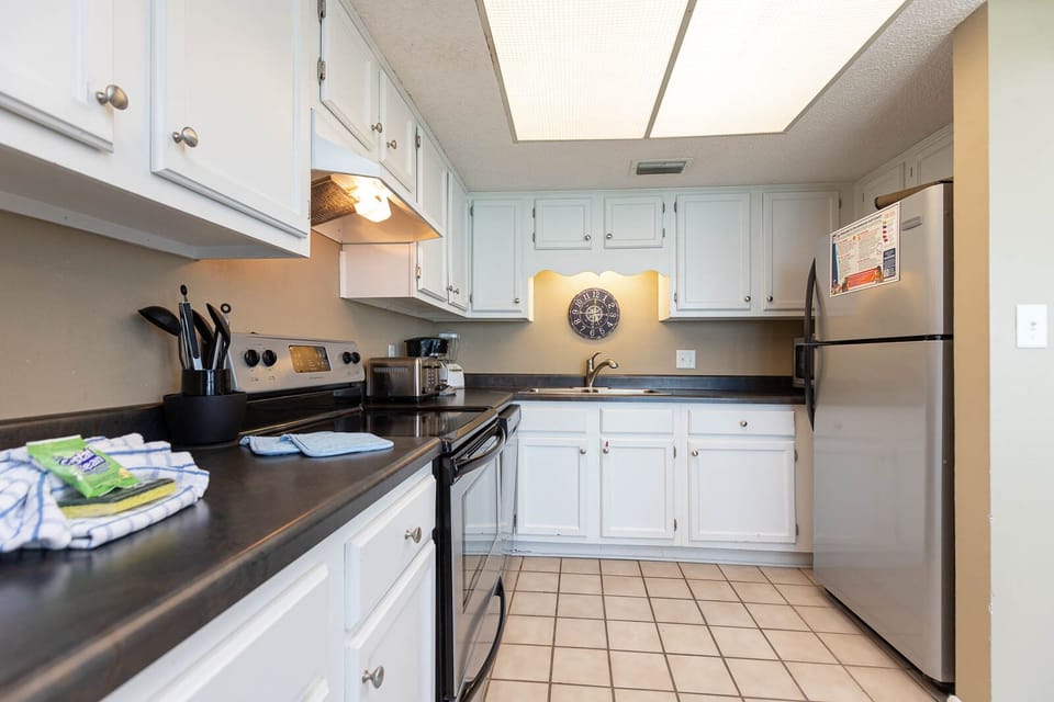 This kitchen features sleek countertops and cabinetry, stainless appliances, and a convenient coffee maker for your stay