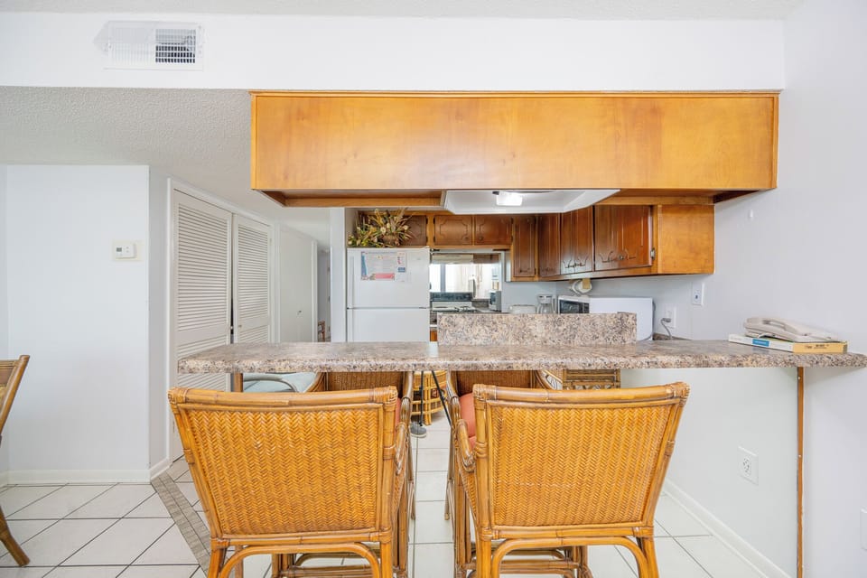 Kitchen with wooden cabinetry and a cozy breakfast bar, perfect for enjoying morning coffee