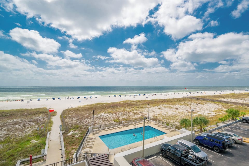 Enjoy a vibrant view of the beach and pool area, perfect for relaxing under the sunny skies
