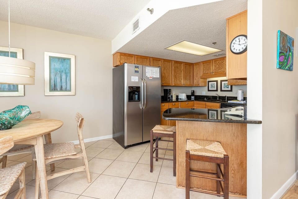 The inviting kitchen features wood cabinetry, a breakfast bar with seating, and a dining area with a round table