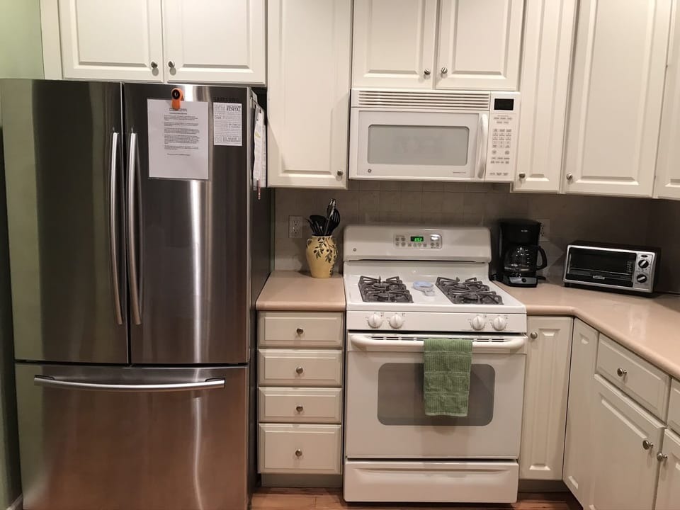 Full L-shaped kitchen with gas oven, microwave, dishwasher & stainless fridge