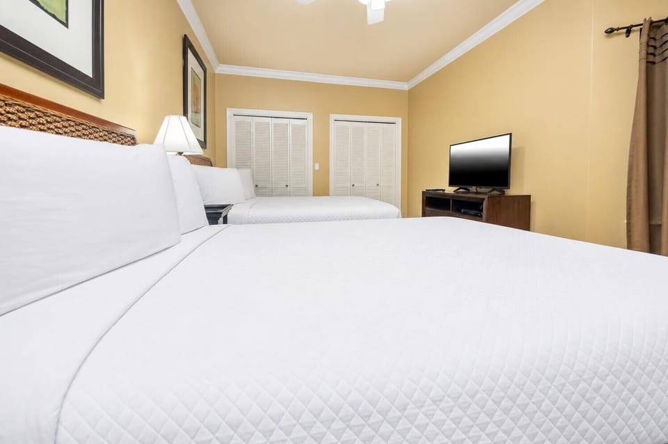 This inviting guest room features two double beds and a TV, creating a relaxing vacation vibe