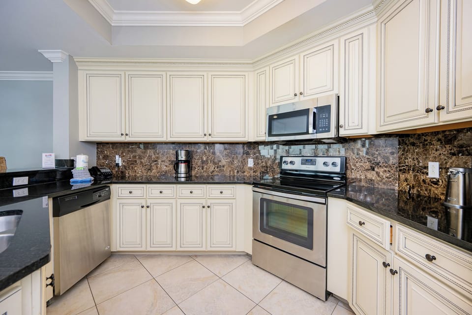 Prepare delicious meals with your loved ones in this inviting kitchen, featuring elegant cabinetry and stainless appliances