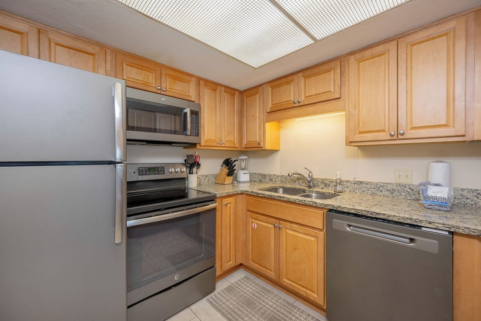 Bright kitchen featuring stainless appliances, granite countertops, and warm wood cabinetry, perfect for culinary adventures