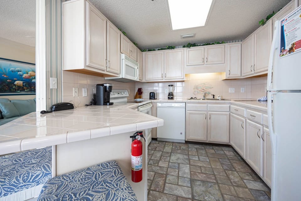 The kitchen features light cabinetry, a breakfast bar, and a Keurig coffee maker for the perfect morning brew