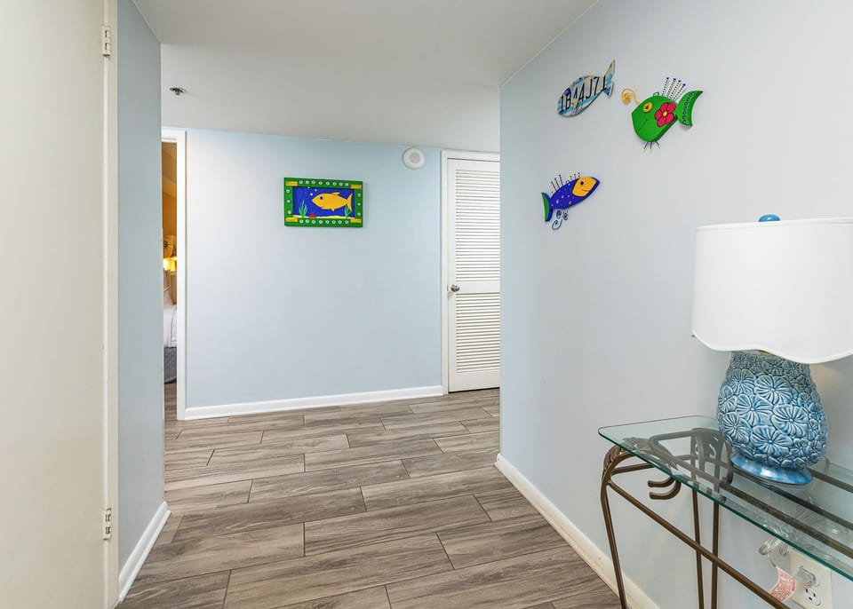 Step into a welcoming entryway adorned with colorful fish decor, a stylish mirror, and a console table