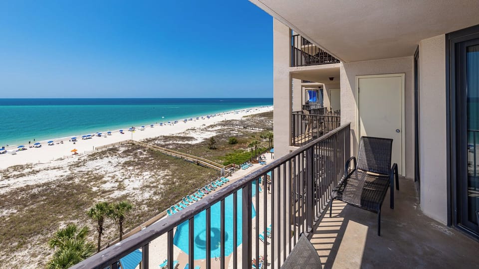 Gaze at the beach and inviting pool from the balcony, perfect for relaxing after a day of fun in the sun