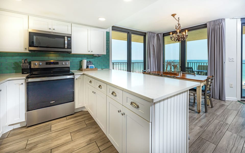 Prepare meals in this stylish kitchen featuring sleek appliances, ample counter space, and vibrant tile accents
