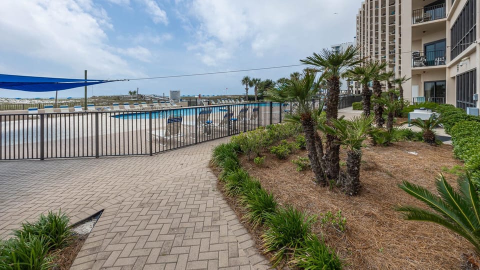 Relax by the pool surrounded by palm trees, with lounge chairs ready for your enjoyment under the blue sky