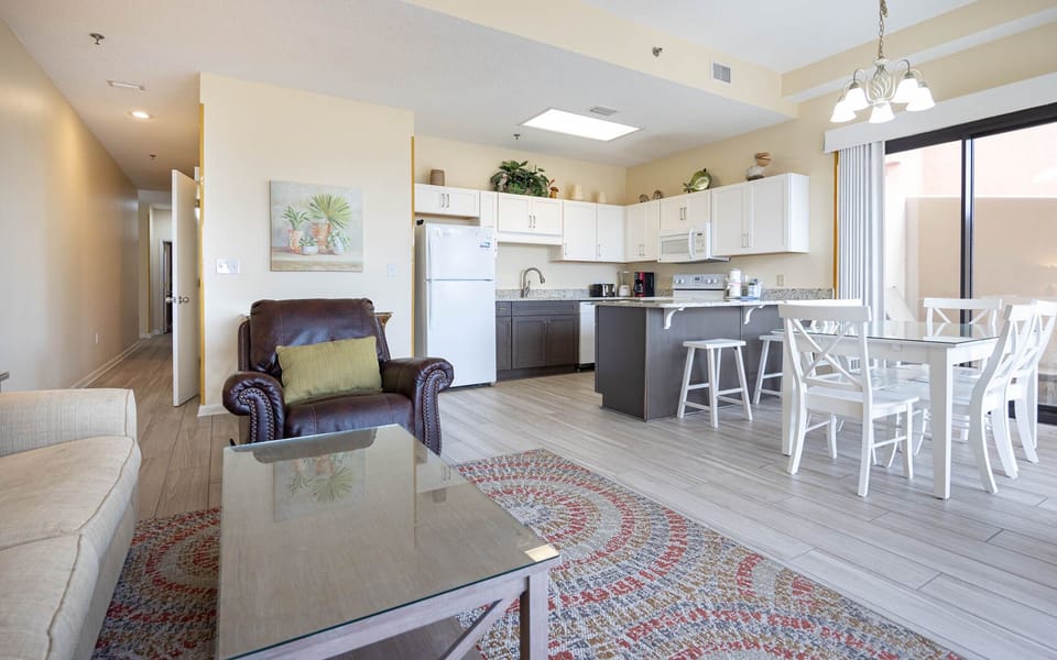 Relax in the spacious living area with comfortable seating, a stylish rug, and a dining table perfect for meals together