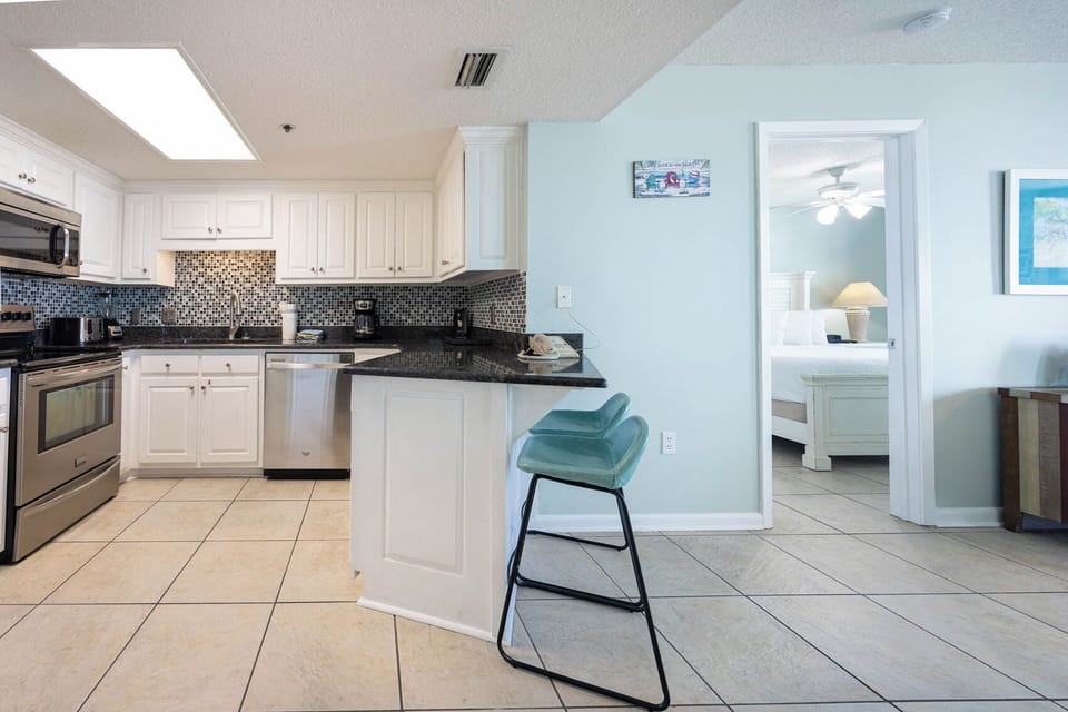 Prepare meals in this kitchen, featuring stainless appliances and a breakfast bar area for casual dining
