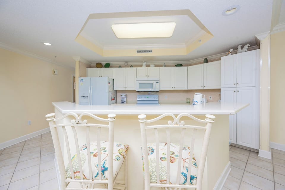 Enjoy a morning coffee at the inviting bar stools, soaking in the bright kitchen's cheerful ambiance