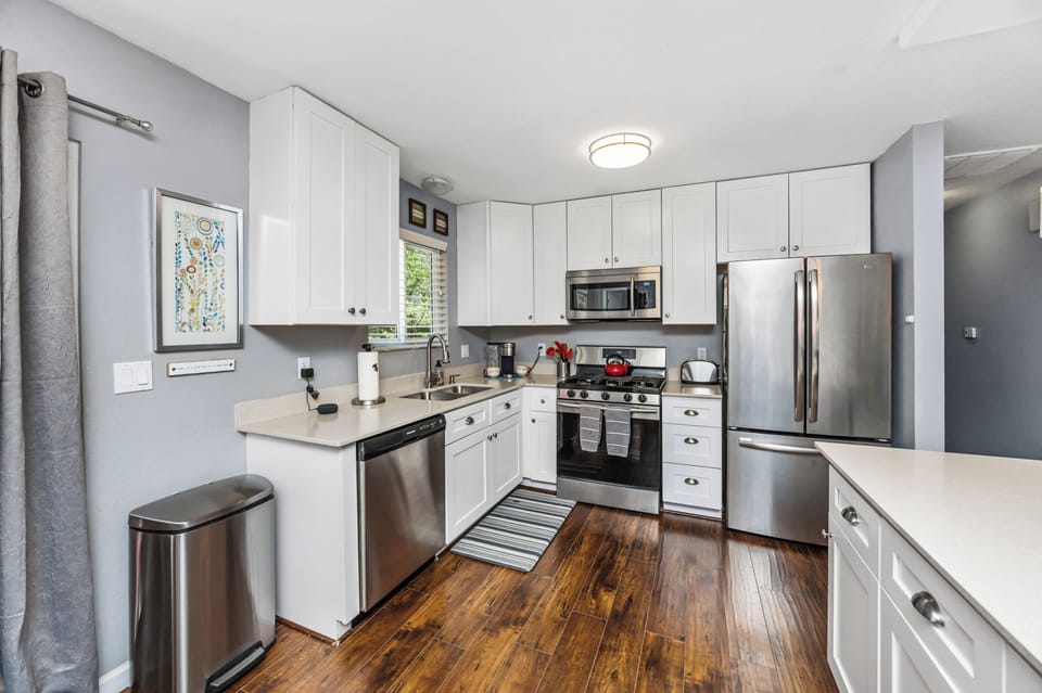Kitchen w/ gas range, dishwasher, quartz counters, equipped to delight the cook.