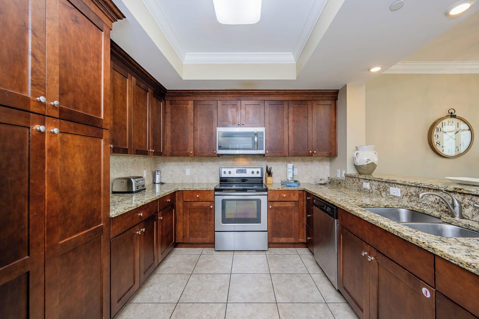 Prepare meals in this stylish kitchen, featuring rich wood cabinetry and stainless appliances