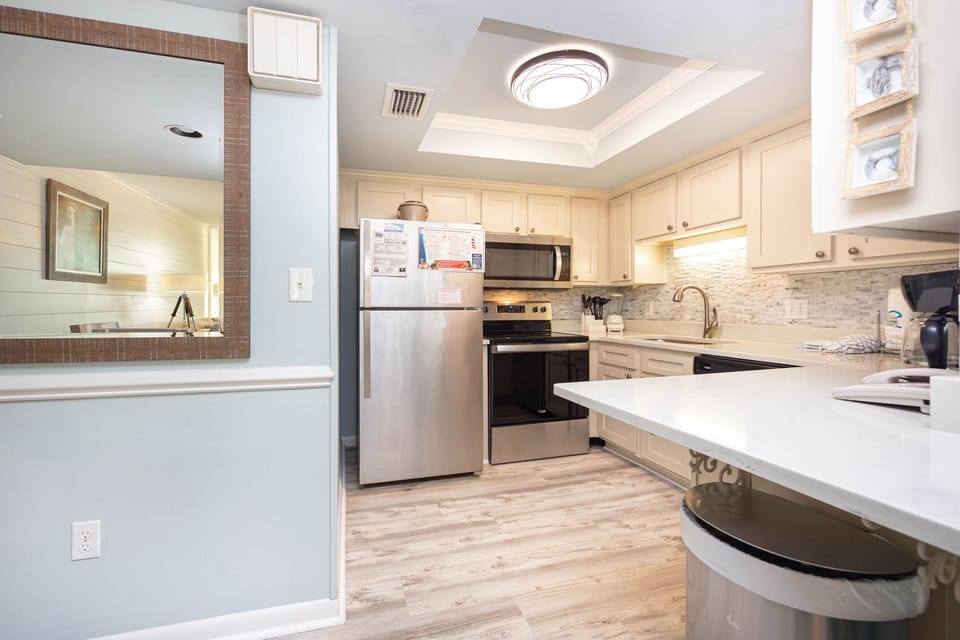 This kitchen features stainless appliances, a coffee maker, and a spacious countertop, perfect for meal preparation