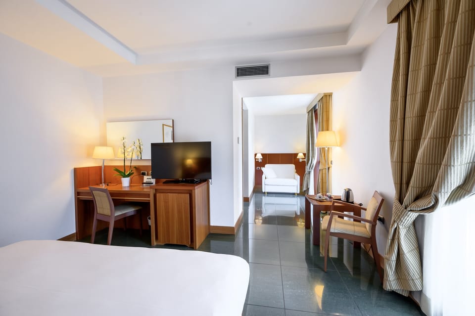 Deluxe Triple Room | Minibar, in-room safe, desk, laptop workspace