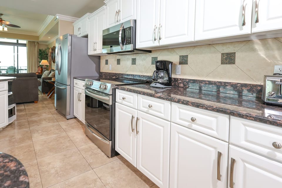 Prepare meals in this kitchen with elegant cabinetry, stainless appliances, and stylish backsplash