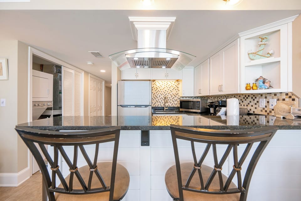 Gather around the sleek countertop, where you'll create cherished memories in this stunning kitchen