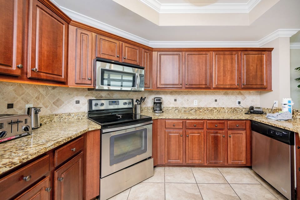 Modern kitchen featuring rich wood cabinetry, stainless appliances, and elegant granite countertops for a stylish experience