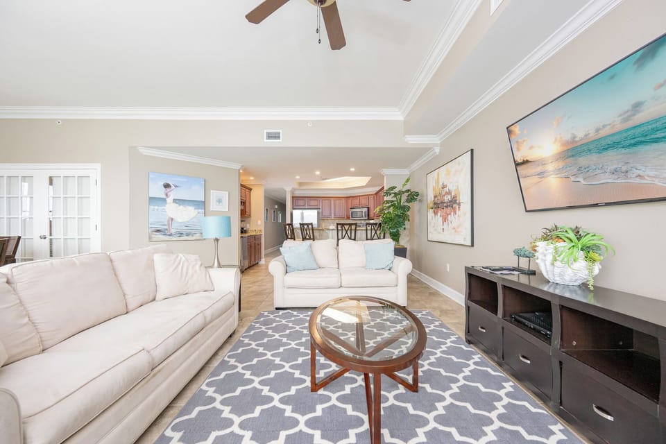 Living area featuring a cozy sofa with queen sleeper, modern decor, and a view of the open kitchen area