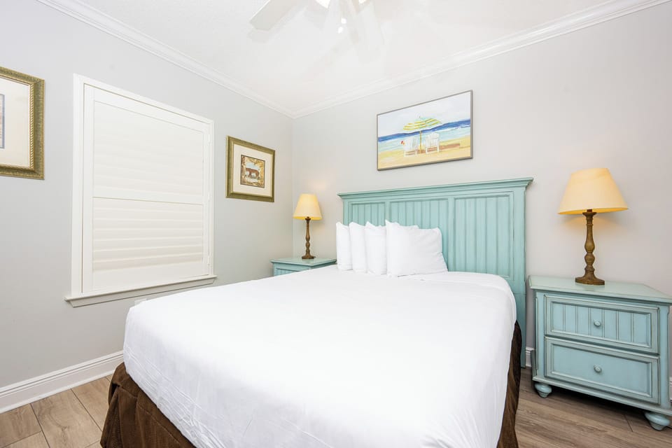 Rest in this tranquil guest bedroom featuring a comfortable queen bed, soft linens, and charming decor for a peaceful sleep