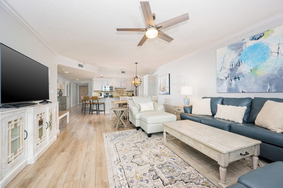 Unwind in the airy living space featuring comfortable seating, a large TV, and a stylish dining area for meals together