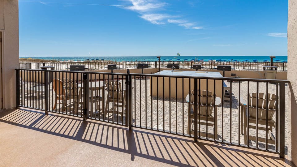 Step onto the outdoor area with seating and grills, perfect for enjoying the refreshing breeze and beach views