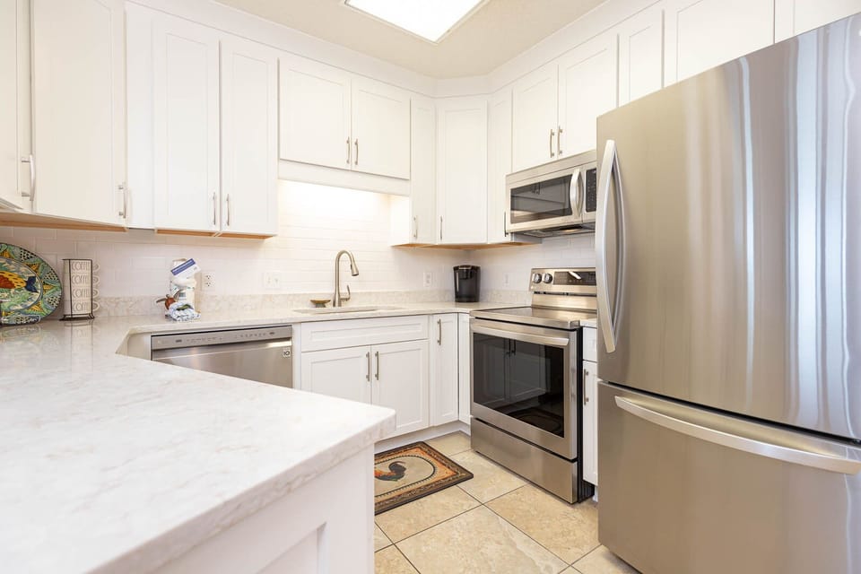 Cook and gather in this bright kitchen featuring stainless steel appliances, ample counter space, and colorful decor