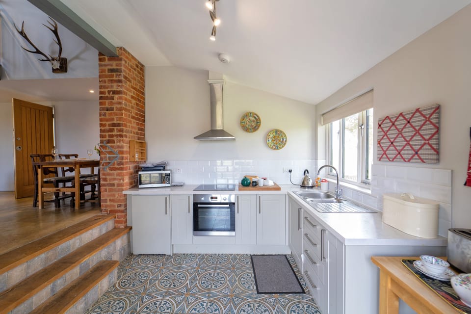 The Buttery, Freston: Kitchen with electric hob, fridge and microwave and steps leading to the open sitting and dining area