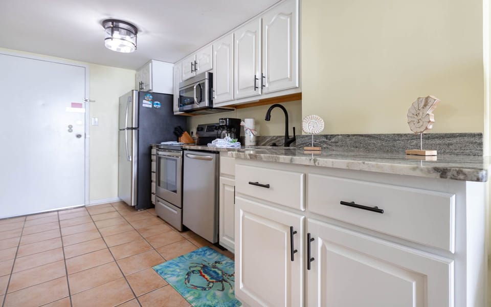 The kitchen features stainless appliances, granite countertops, and decorative accents, perfect for a delightful experience