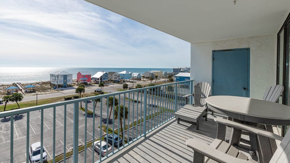 This balcony offers a stunning beach view, featuring comfortable seating and a relaxing atmosphere for guests to enjoy