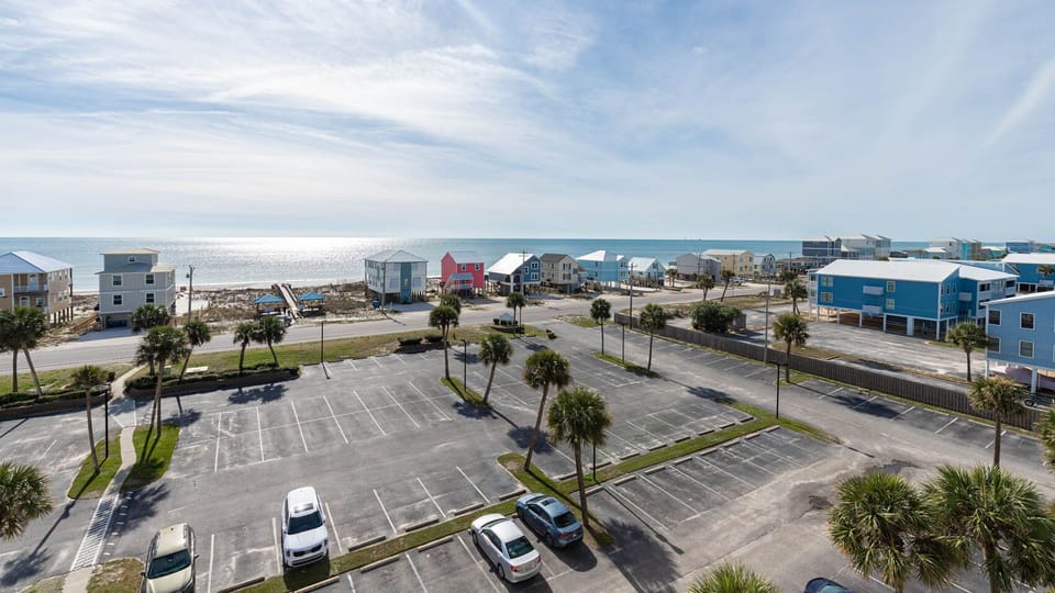 This view showcases a serene beachside scene with colorful beach houses and palm trees, inviting relaxation and fun