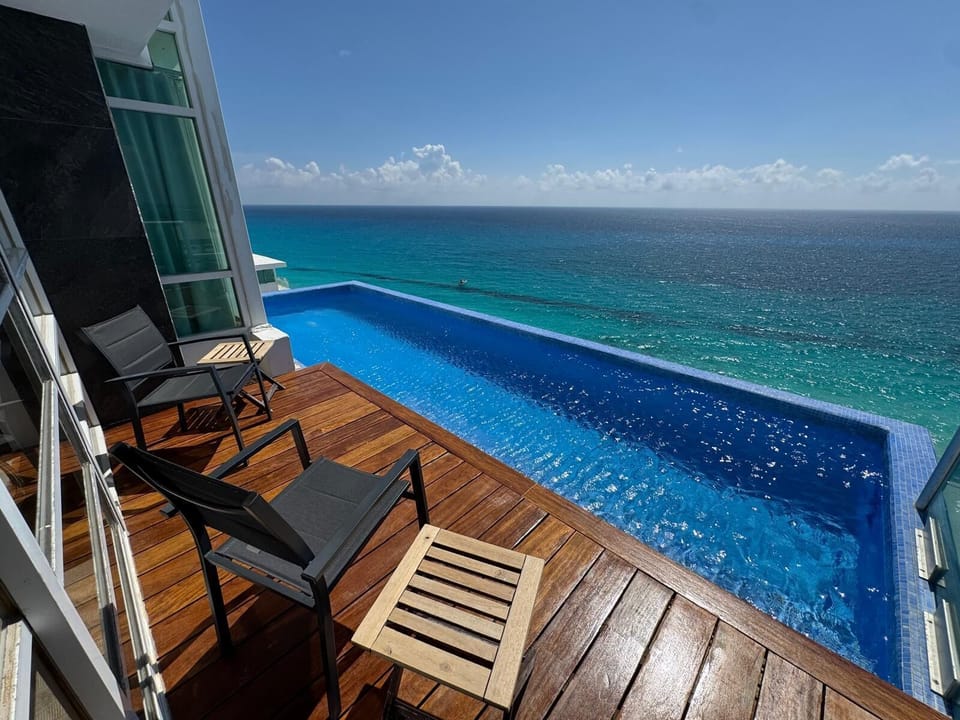 The Heated Main Level Infinity Pool is kept at a toasty 92 degrees.  Beyond the pool is the roof, about 6 ft below the edge.