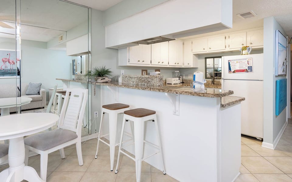Bright and inviting kitchen with granite countertops, bar seating, and a cozy dining area perfect for meals and gatherings