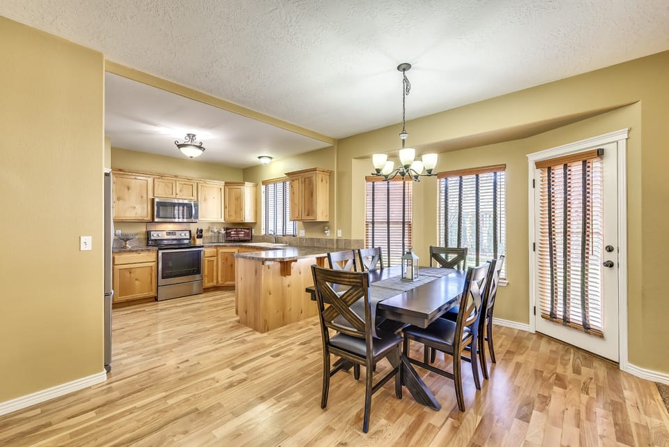 Large dining room with mulitple windows for backyard views. Extra chairs & leaf.