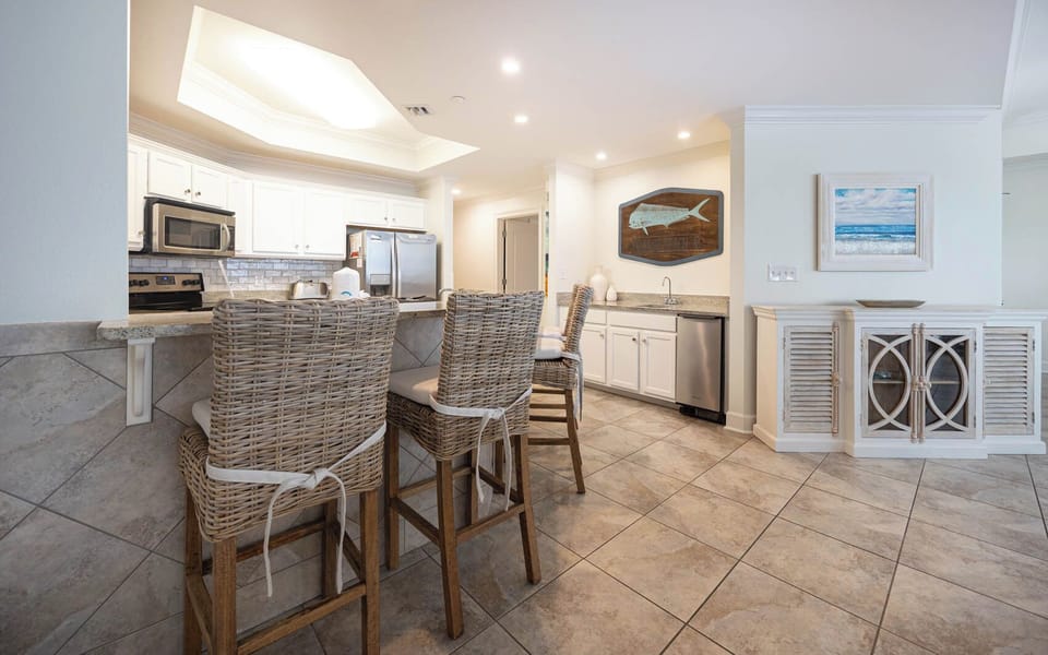 The kitchen features stainless appliances, granite countertops, and a stylish bar, perfect for casual dining and entertaining