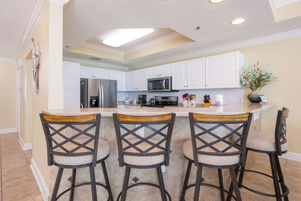 Gather around the stylish bar area with comfortable seating in the modern kitchen area for effortless meal prep