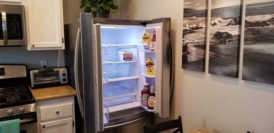 Refrigerator is stocked with ketchup, mustard, mayo, bbq & hot sauce and butter.