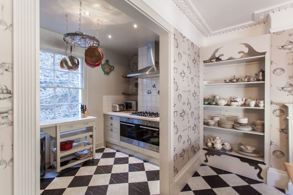 Fully equipped kitchen/diner with vintage cake stands, crockery and cutlery