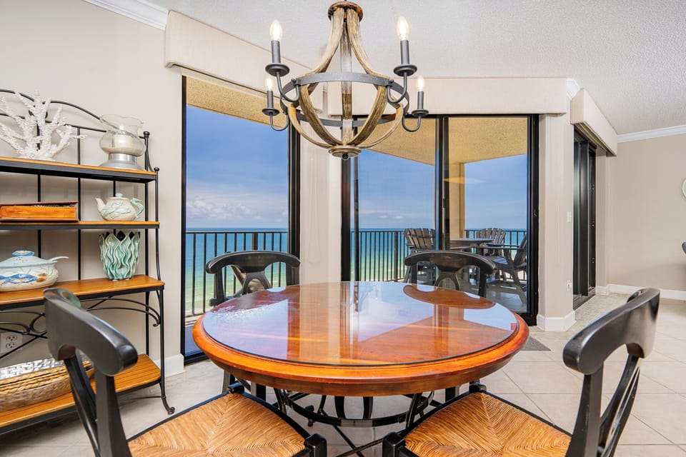 Gather around the round dining table to enjoy meals while admiring the expansive water views through the large windows