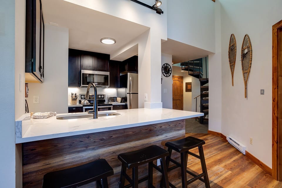 Your modern kitchen features sleek countertops, stainless steel appliances, and a breakfast bar perfect for casual dining or morning coffee.