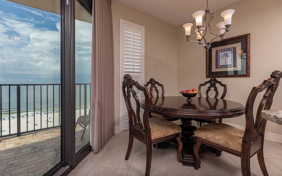 Dine at the elegant table with a view of the tranquil waters and beach chairs just beyond the sliding glass doors