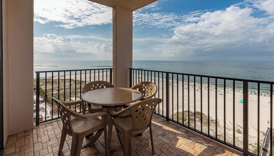 Enjoy meals at the round table while taking in the scenic views of the beach and tranquil waters from your balcony
